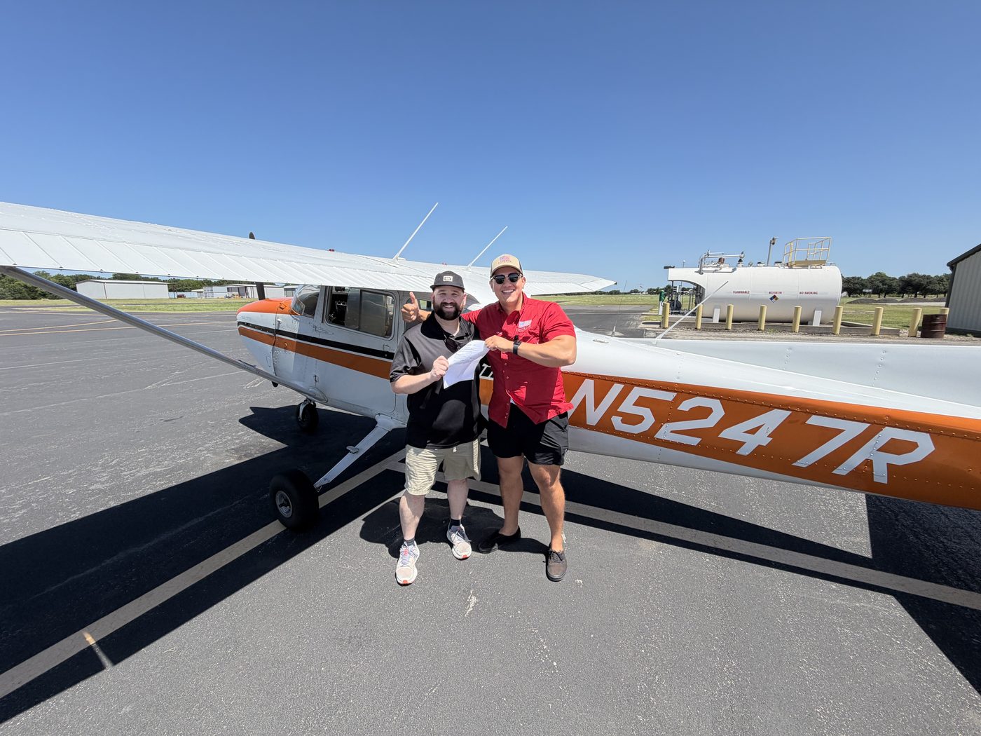 Adam Fields celebrating with a student beside Cessna 172 N5247R