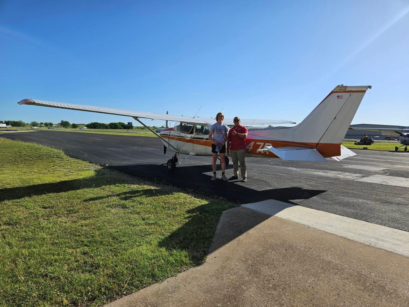 Adam Fields and a student on the ramp beside Cessna 172 N5247R after a solo flight